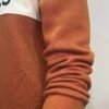 Sleeve close-up of Wearees burnt orange cotton fleece sweatshirt