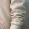 Close-up of sleeve cuff detail on Wearees white cotton fleece hoodie.